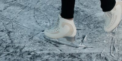 a woman on ice with white skates and black trousers