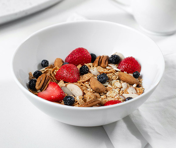 breakfast with a bowl of cereal with nuts, berries and oats
